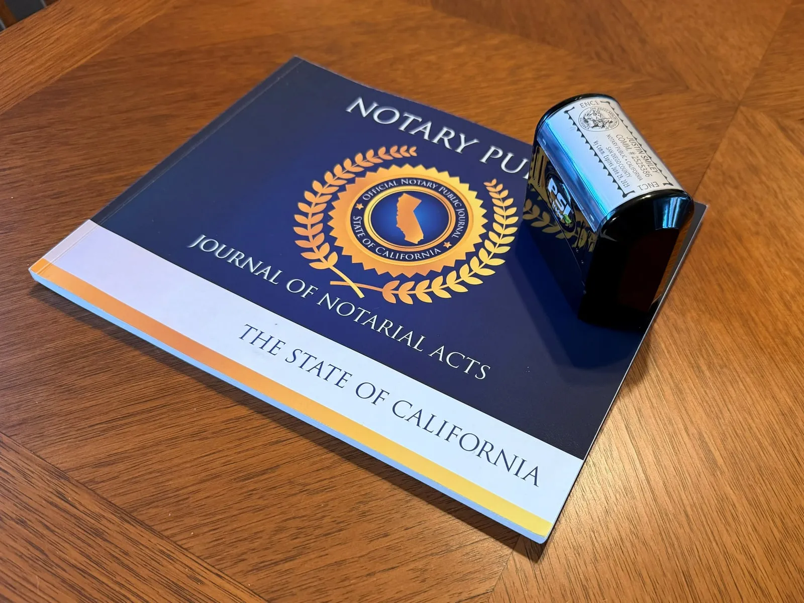 A California notary journal of notarial acts beside an inked seal