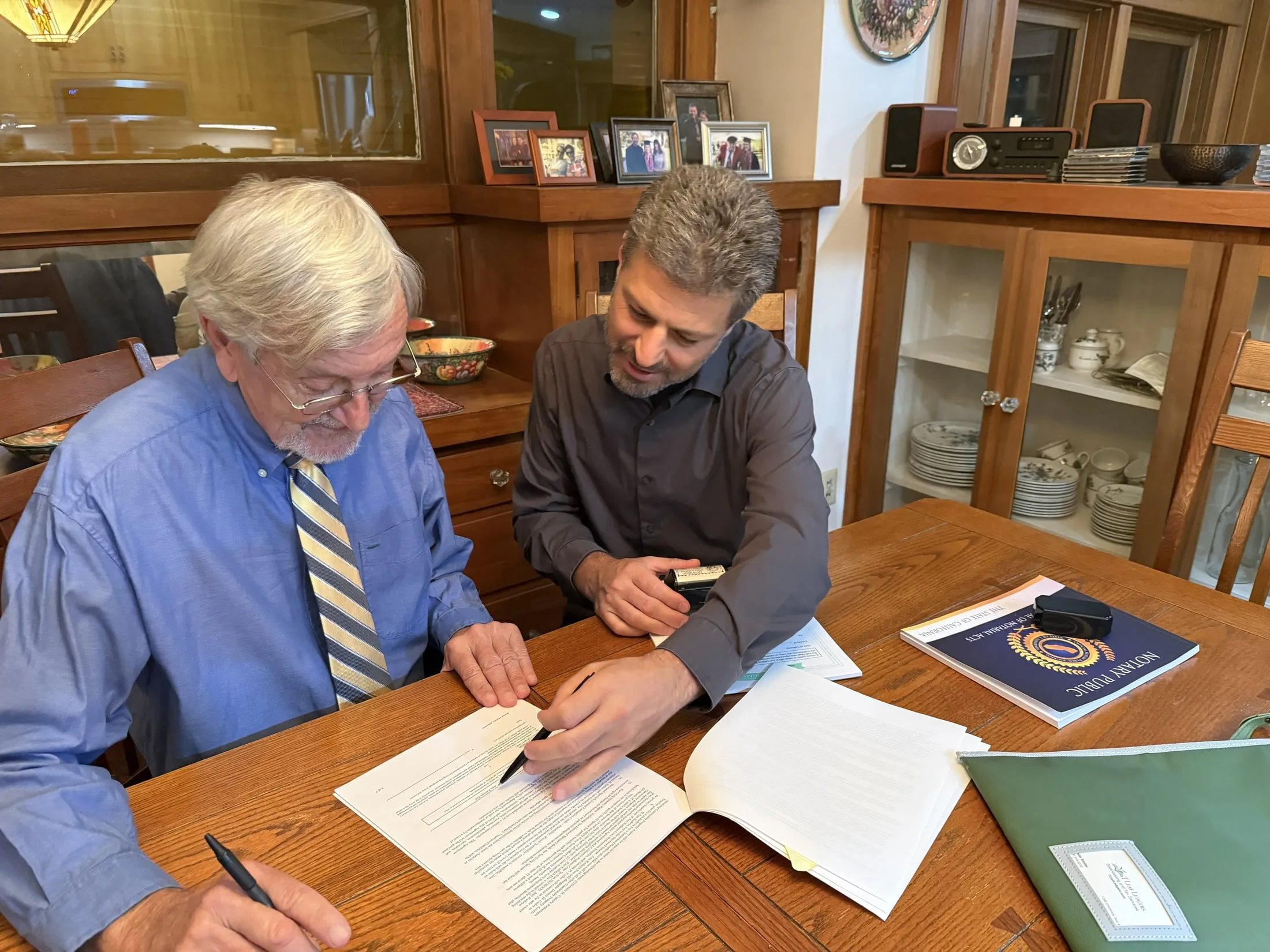 Justin Smiley guiding a client through a document at their dining table in San Diego